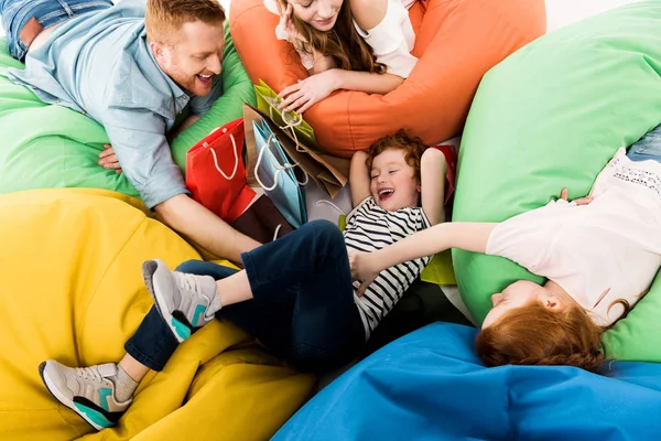 Familia en sillas bolsa de frijol después de ir de compras — Foto de Stock