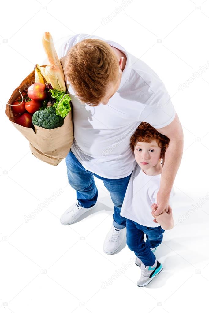 father and son with grocery bag