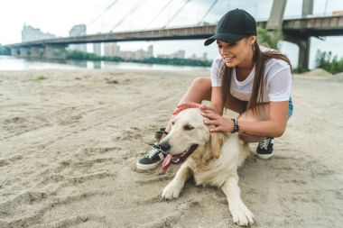 Kumsalda köpeği olan bir kadın.