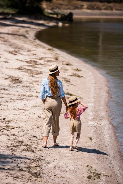 Mutter und Tochter gehen am Strand spazieren — kostenloses Stockfoto