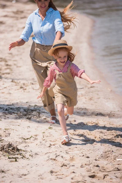 Mãe e filha correndo na praia — Fotografia de Stock