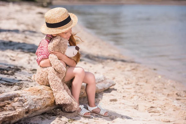 Child with teddy bear at seashore — Stock Photo, Image