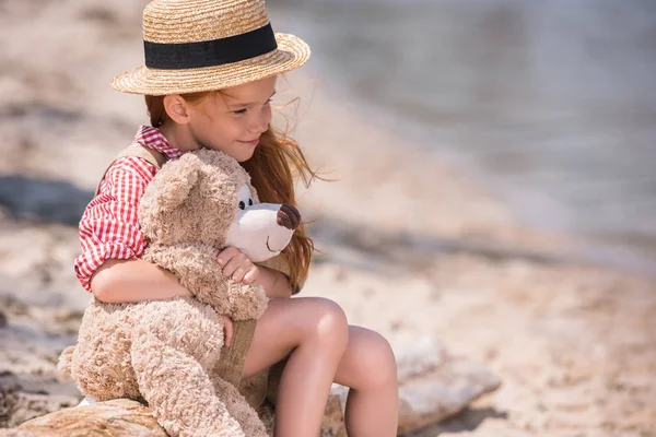 Niño con osito de peluche en la orilla del mar —  Fotos de Stock