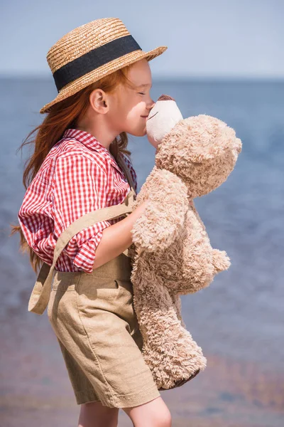 Niño con osito de peluche en la orilla del mar —  Fotos de Stock