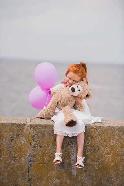 Child with teddy bear and balloons — Stock Photo, Image