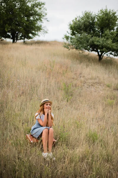 Young woman sitting on suitcase — Stock Photo, Image