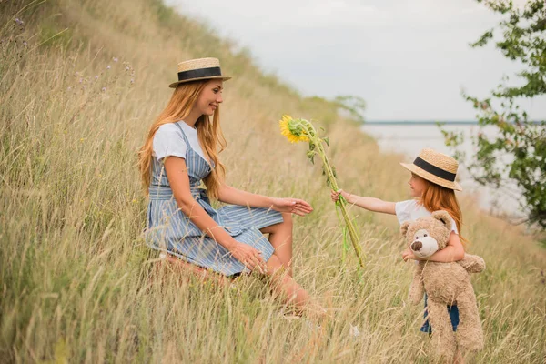 Moeder en dochter met zonnebloemen — Stockfoto