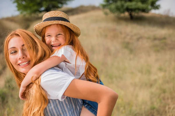 Madre piggybacking hija — Foto de Stock