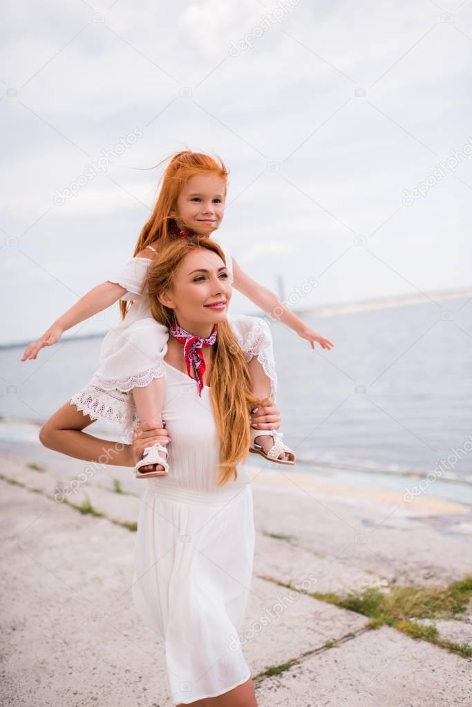 mother carrying daughter