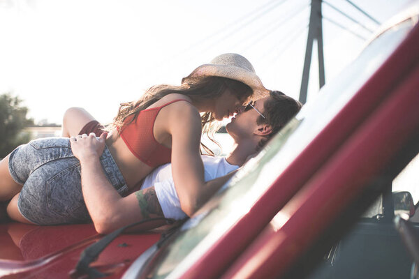 couple kissing on car hood