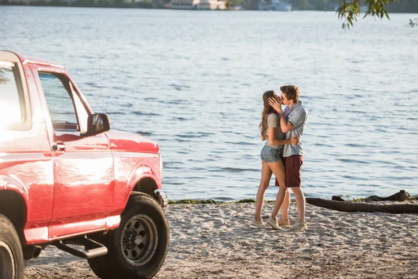 Pareja joven besándose en la playa — Foto de Stock