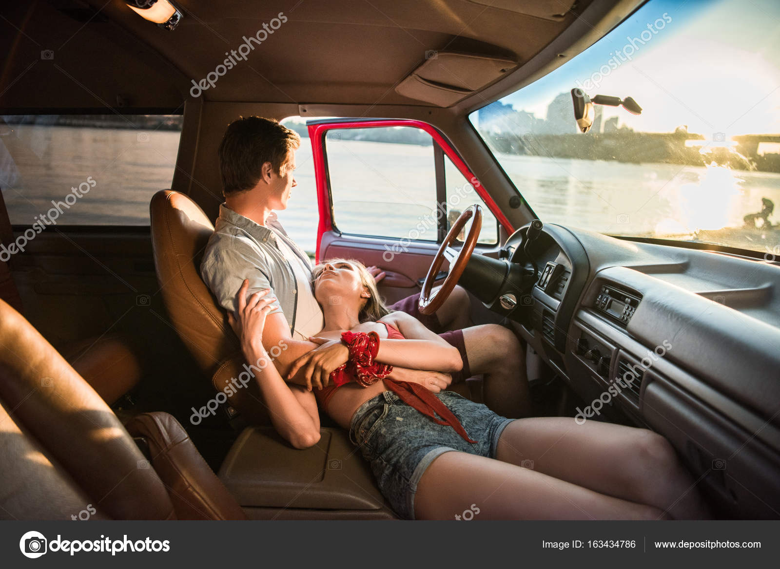Young couple hugging in car — Stock Photo © ArturVerkhovetskiy