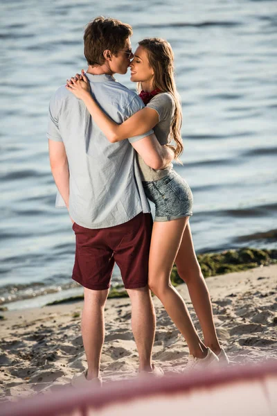Молодая пара обнимается на пляже — стоковое фото