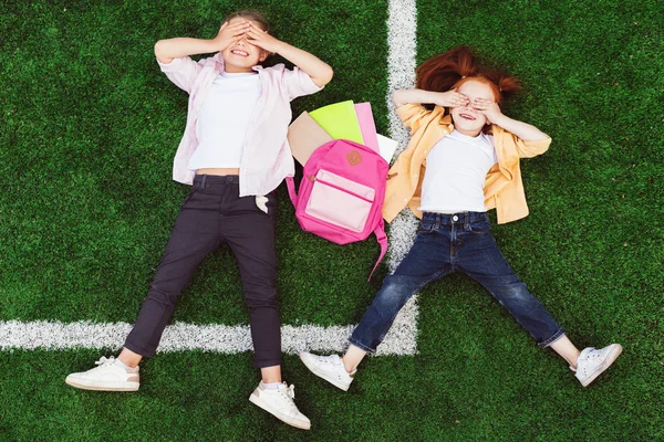 Schoolgirls lying on grass — Stock Photo, Image
