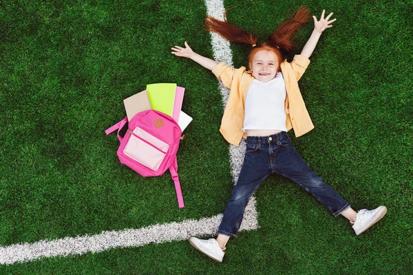 Schoolkid met rugzak op gras — Stockfoto