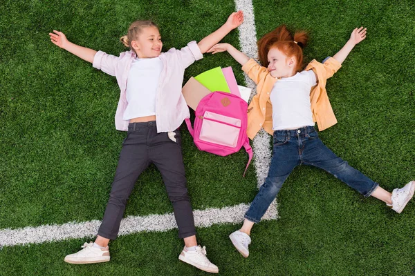 Школьницы лежат на траве — стоковое фото
