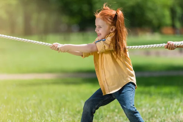 Rothaariges Kind zieht Seil — Stockfoto