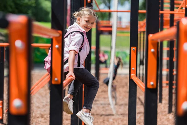 Escolar com mochila no parque infantil — Fotografia de Stock