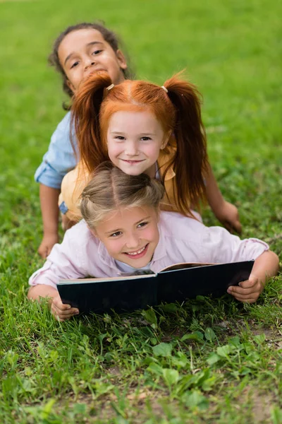 Multiethnische Schulmädchen lesen Buch — Stockfoto