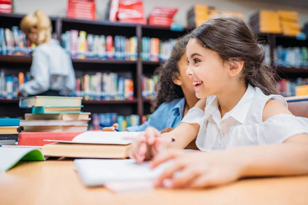 Schoolgirls gossiping at library — Stock Photo, Image