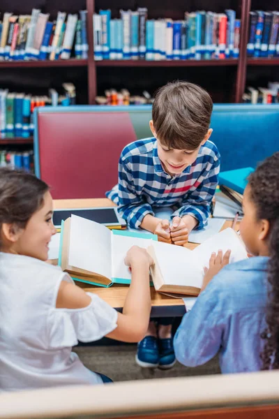 Barnen läsa böcker i biblioteket — Stockfoto