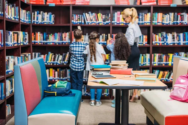 Professor com crianças na biblioteca — Fotografia de Stock