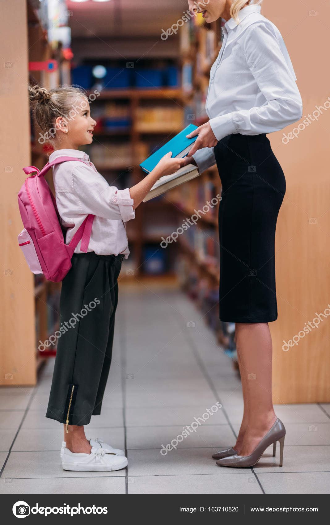 Teacher Giving Books To Schoolgirl Stock Photo Teacher Giving Books To Schoolgirl Stock Photo