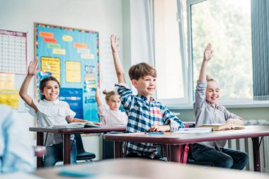 kids raising hands in class