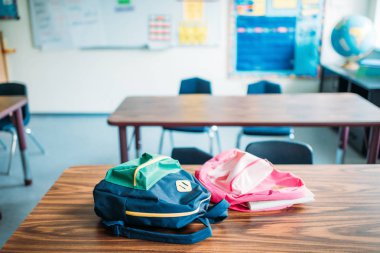 backpacks laying on desk clipart