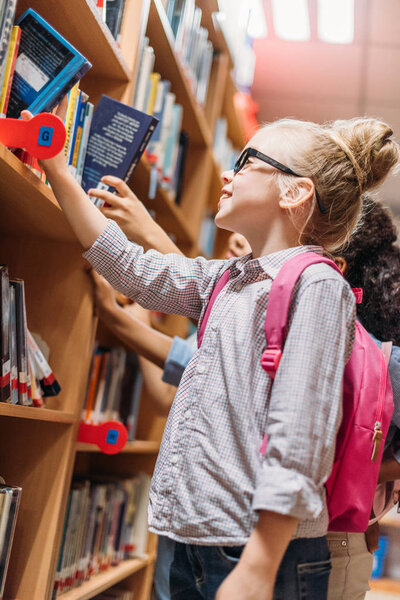 schoolgirls choosing books in library