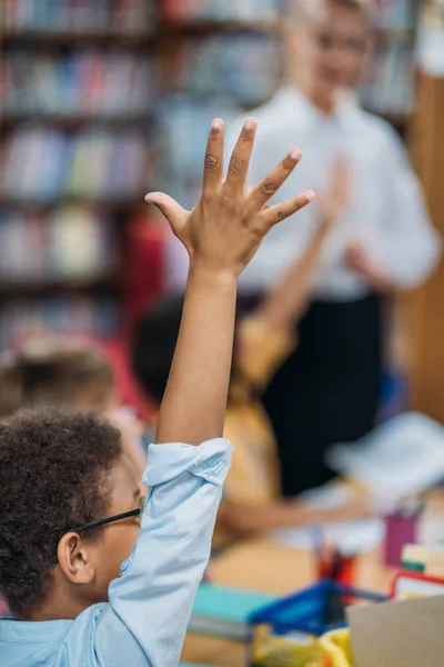 Schooljongen verhogen hand — Stockfoto