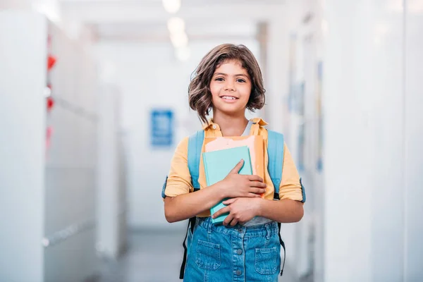 Schoolgirl with backpack and book — Stock Photo, Image