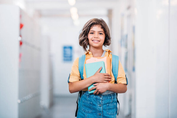 schoolgirl with backpack and book