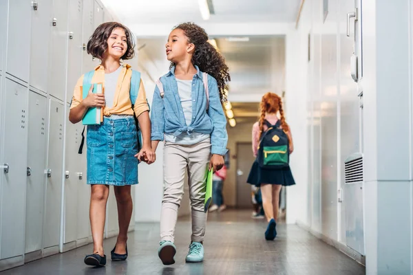 Девочки, идущие по школьному коридору — стоковое фото