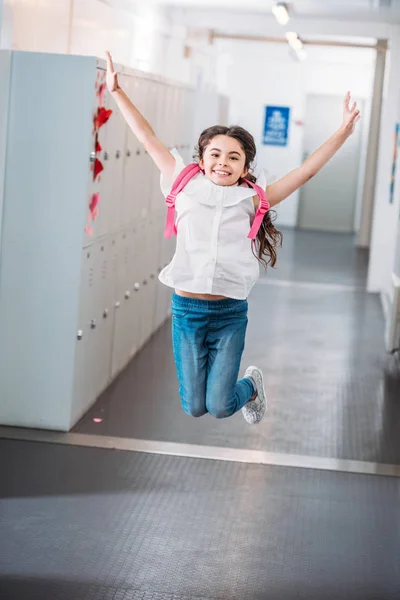 Chica saltando en la escuela pasillo — Foto de Stock