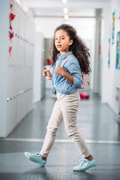 Ragazza a piedi attraverso il corridoio della scuola — Foto Stock