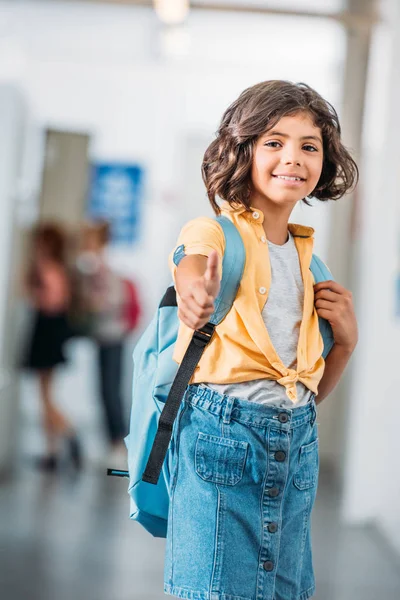 Schoolgirl showing thumb up — Free Stock Photo