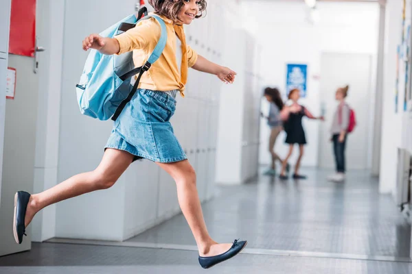 Школьница бежит по школьному коридору — стоковое фото