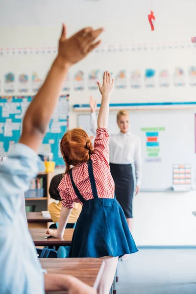 Pupils raising hands on lesson — Stock Photo, Image