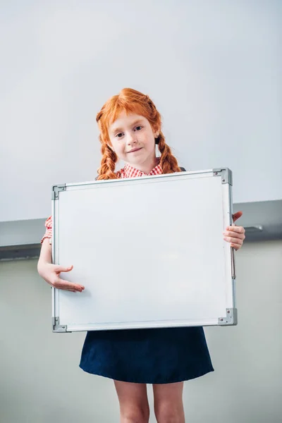 Schoolgirl with blank whiteboard — Free Stock Photo