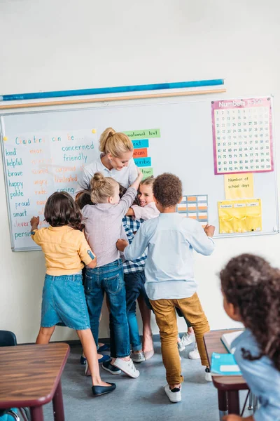 Professor abraçando com alunos — Fotografia de Stock