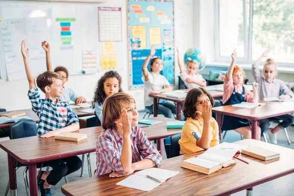 Kinderen verhogen handen in de klas — Stockfoto