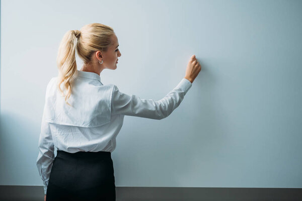 teacher writing on blank whiteboard