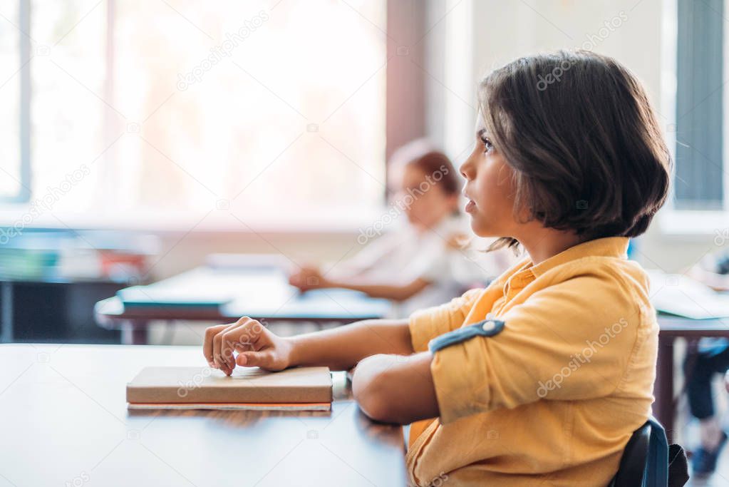 concentrated schoolgirl sitting in class