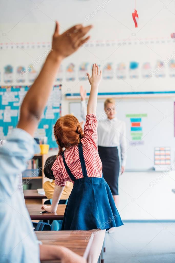 pupils raising hands on lesson