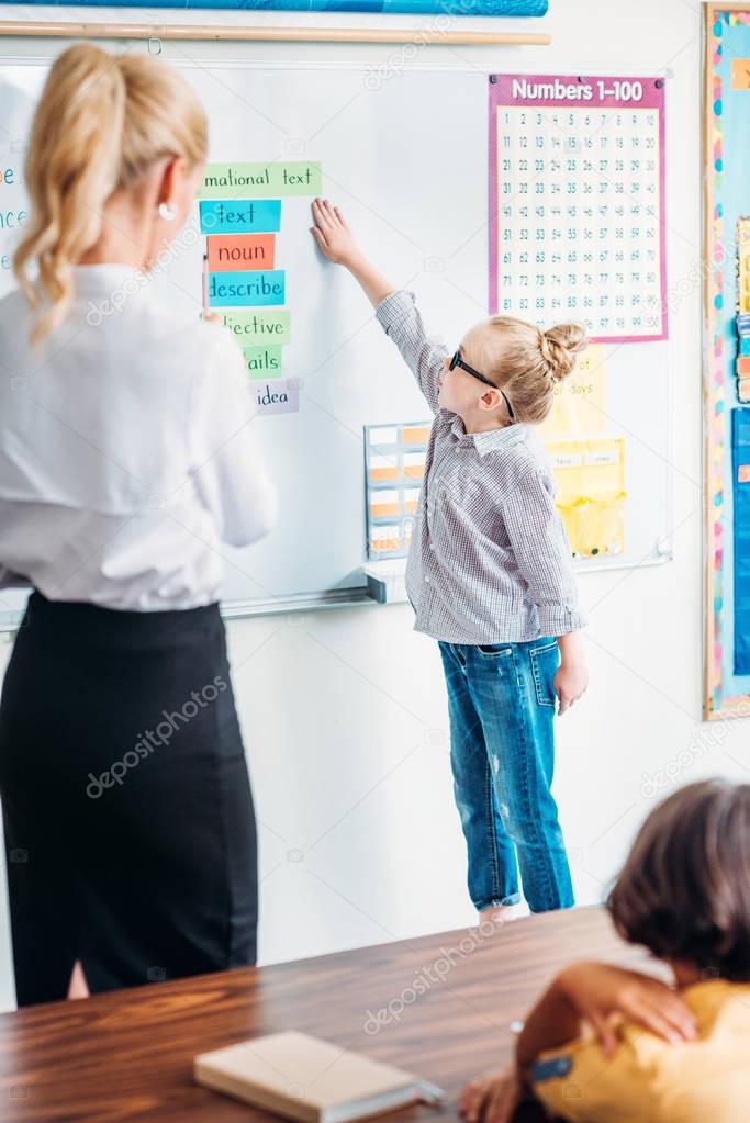 schoolgirl answering next to whiteboard