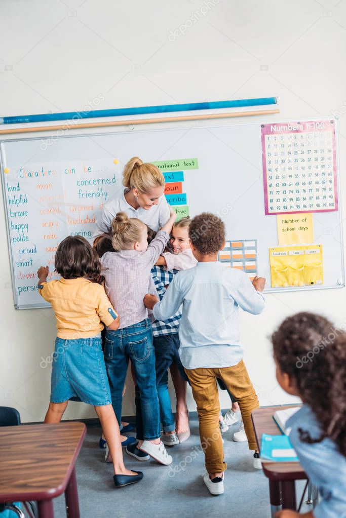 teacher embracing with pupils