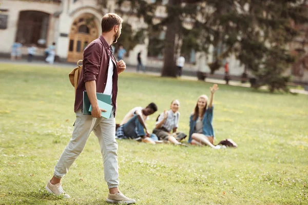 Student met boeken op zoek naar klasgenoten — Stockfoto