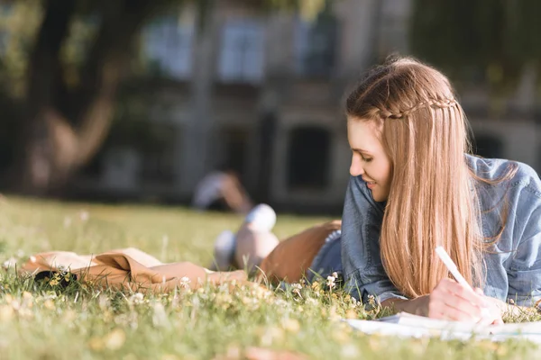 Jonge vrouw studeren in park — Stockfoto