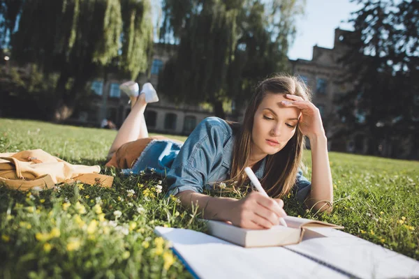 Jonge vrouw studeren in park — Stockfoto